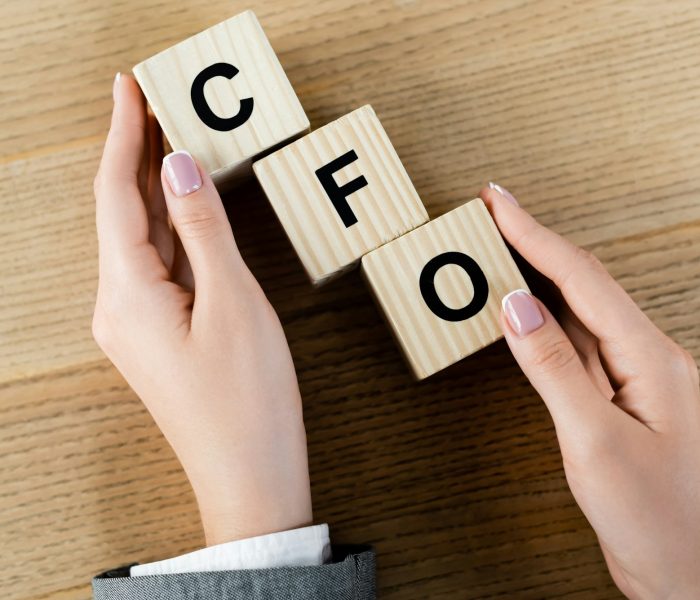top view of businesswoman holding wooden cubes with cfo letters